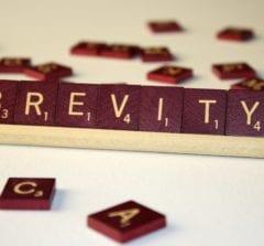 The word "brevity" is spelled out with scrabble tiles